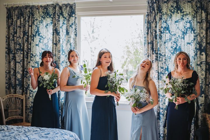 Brooke and her bridal party laughing in the blue toile bedroom