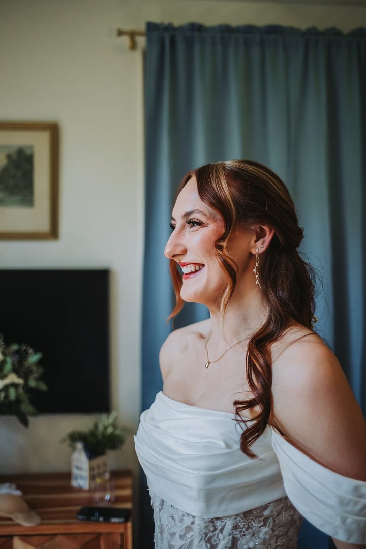 Brooke smiling in the blue toile bedroom before the ceremony
