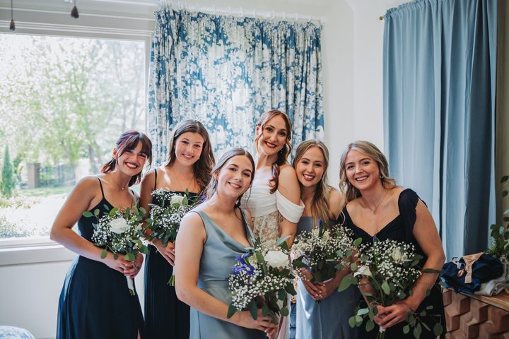 Brooke and her bridal party gathered by the bedroom window