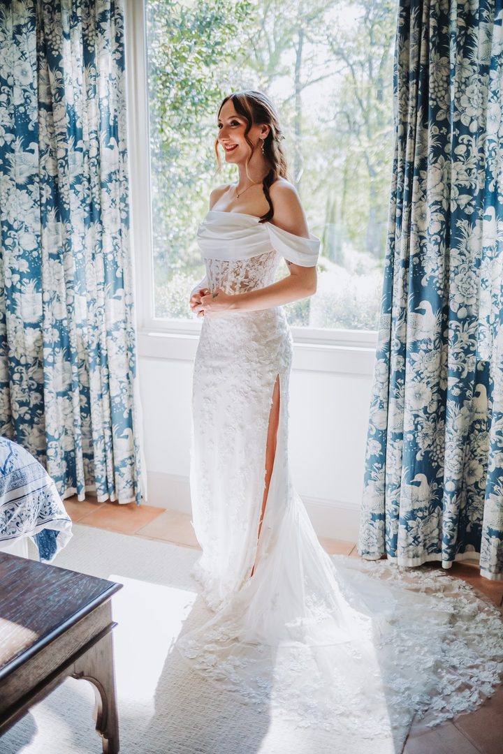 Brooke’s wedding dress and train framed by the blue toile curtains