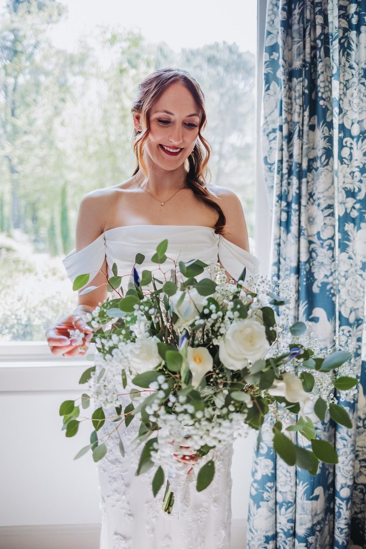 Brooke holding her bouquet of white roses and greenery