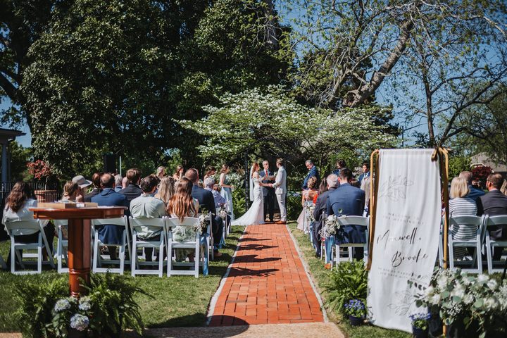 Guests watching the garden ceremony beside the welcome sign