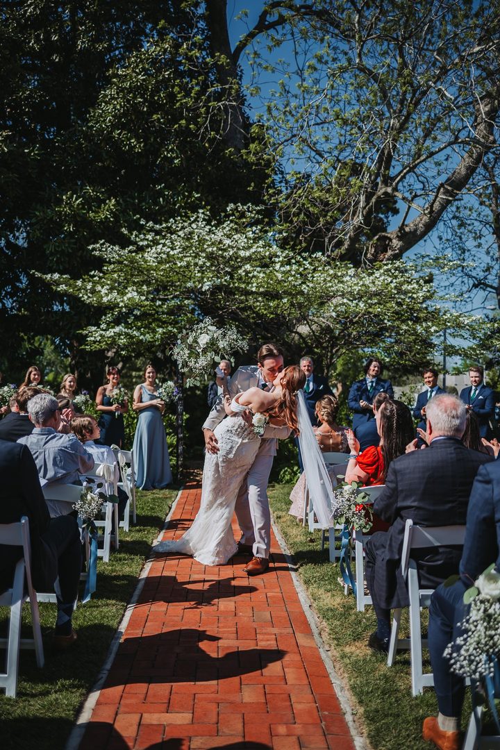 Brooke and Max sharing a kiss on the garden aisle