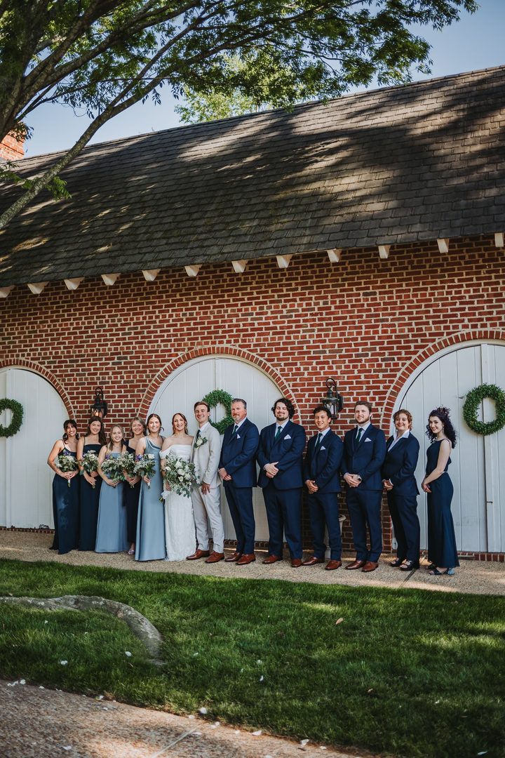 A portrait of the wedding party beneath the Carriage House roof