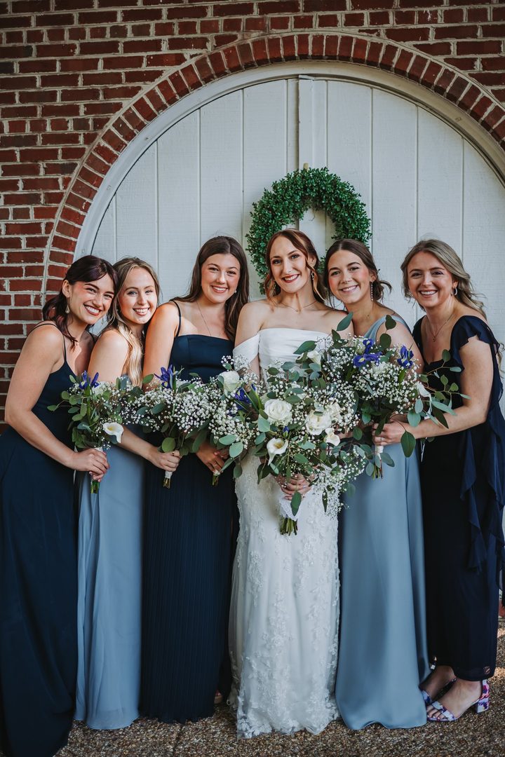 Brooke and her bridal party beneath an arched Carriage House doorway