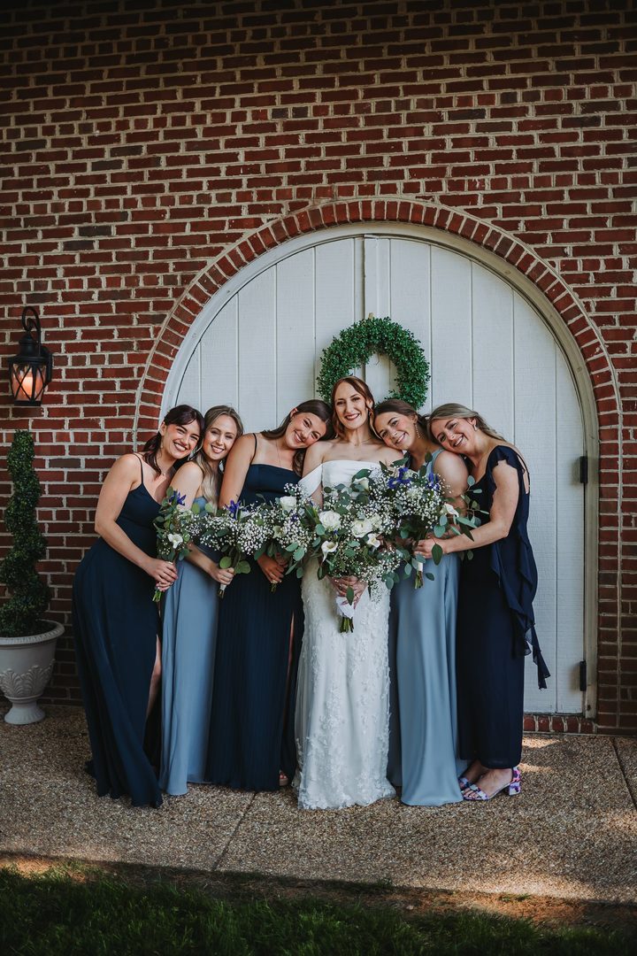 Brooke and her bridal party smiling outside the Carriage House