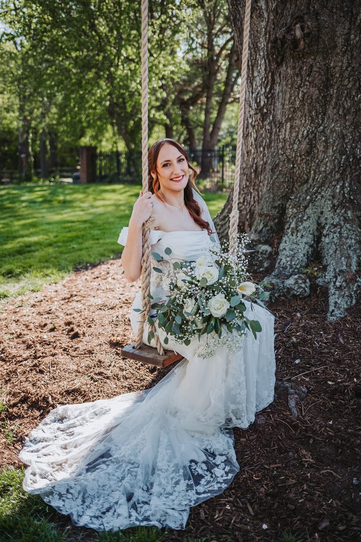 Brooke holding her bouquet beside the old oak tree