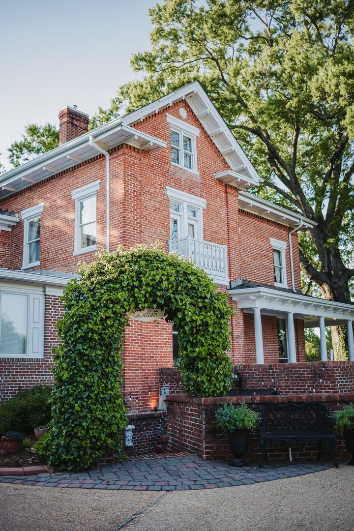 The historic brick Manor framed by spring trees