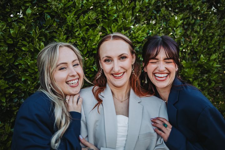 Brooke smiling with two members of her bridal party