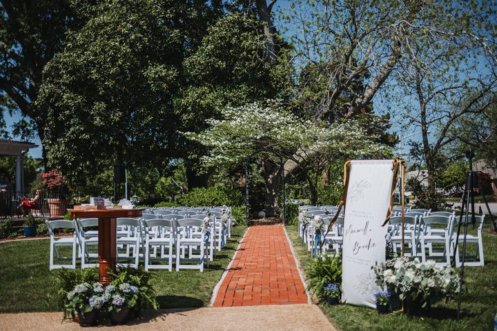 White flowers and a welcome sign at the garden ceremony entrance