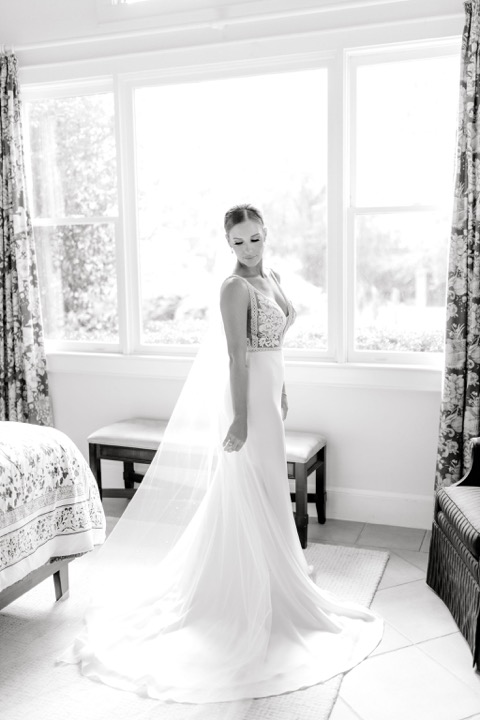 A black-and-white bridal portrait by the cottage window