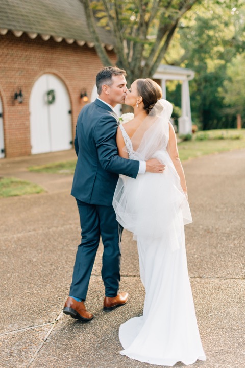 The couple kissing outside the Carriage House