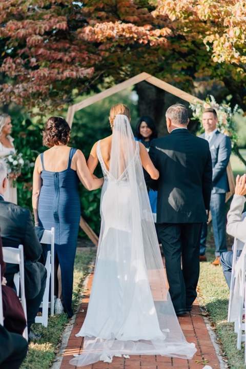 A view of the couple beneath the wooden ceremony arbor
