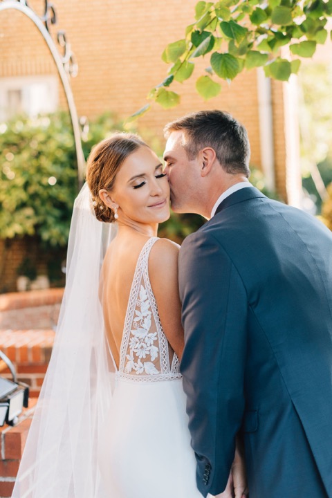 The newlyweds sharing a kiss on the Manor porch