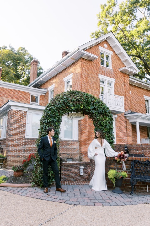 Madelynne and Parker standing by the Manor’s ivy-covered archway