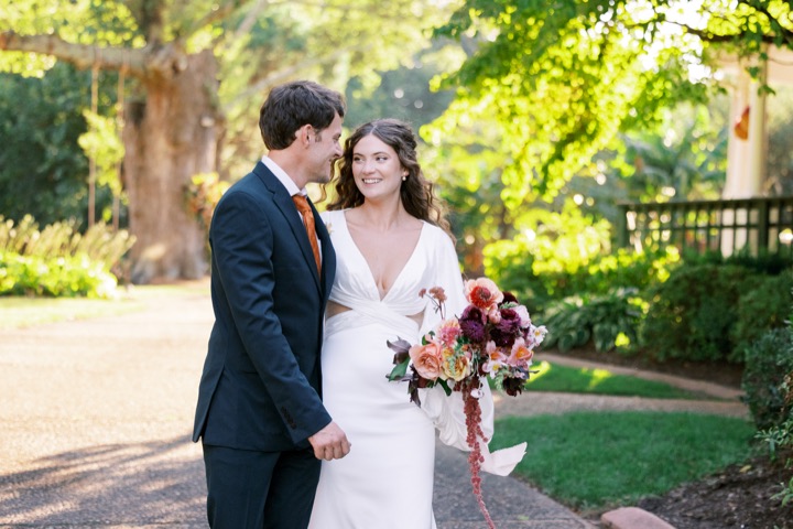 A close portrait of Madelynne and Parker with her autumn bouquet