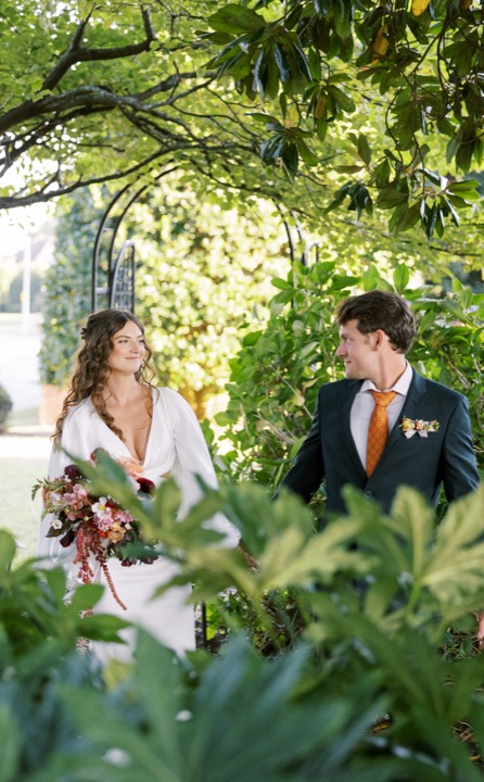 Madelynne and Parker framed by leafy garden branches