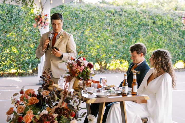 Madelynne and Parker listening to a toast at their reception