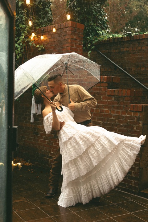 Casey twirling Kali beneath an umbrella beside the garden steps