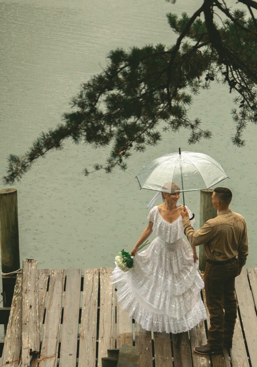 Casey and Kali together under an umbrella by the water