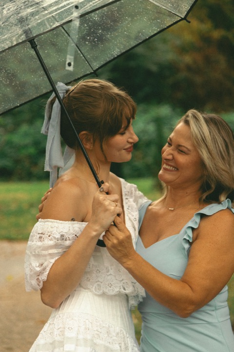 Kali sharing a laugh with a guest beneath an umbrella