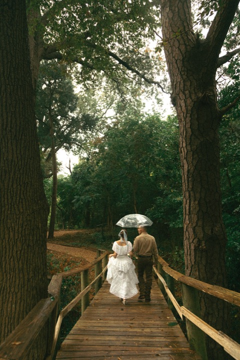 Casey and Kali walking across the wooded garden bridge