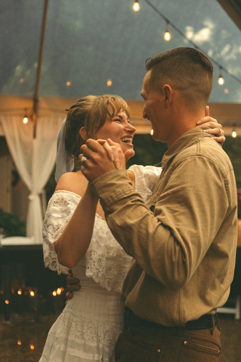 Casey and Kali dancing together beneath string lights