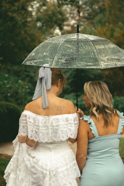 Kali and a guest sharing an umbrella in the gardens