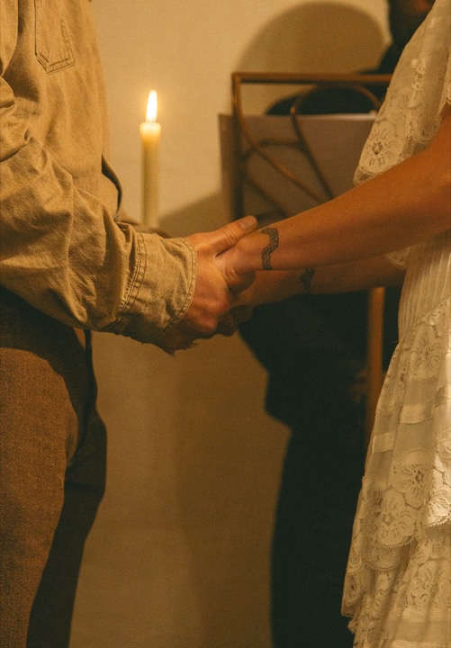 The couple holding hands in the candlelit Cellars