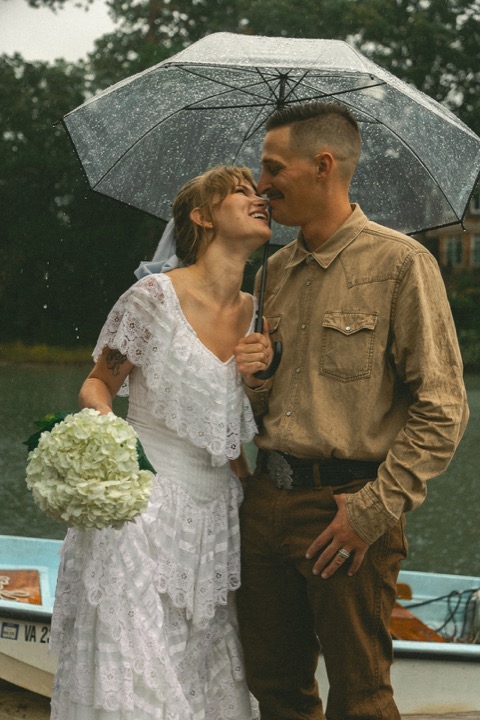 Casey and Kali sharing a kiss beneath their umbrella