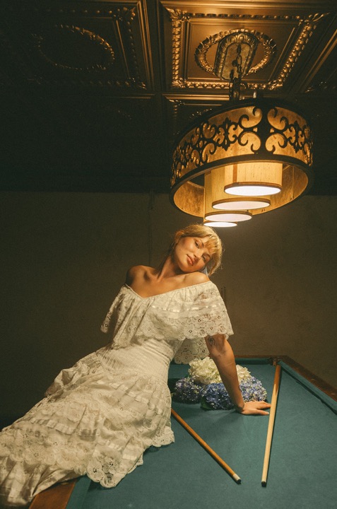 The couple posing playfully beside the billiards table
