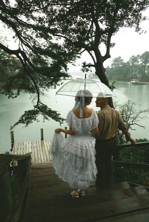 Casey and Kali standing on the waterfront dock in the rain