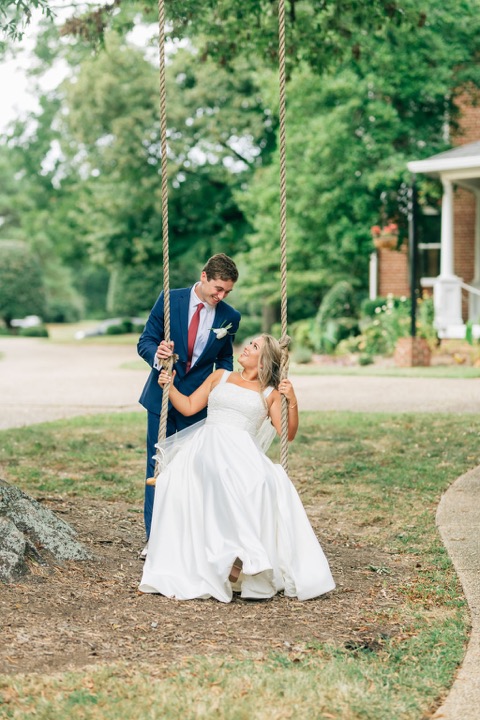 Tyler and Kate holding hands beneath the garden trees