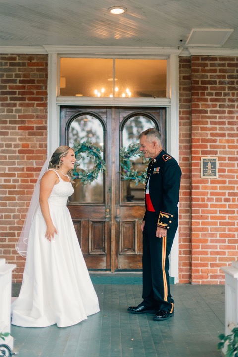 The couple reaching for each other by the Manor’s front doors