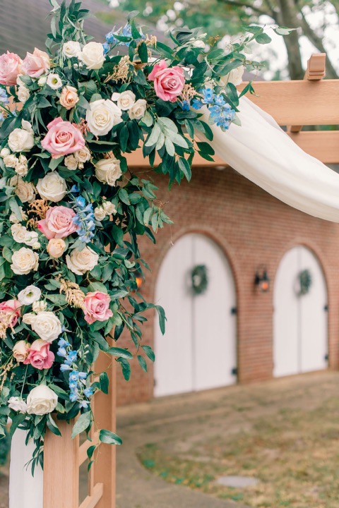Pink and white roses decorating the ceremony arbor
