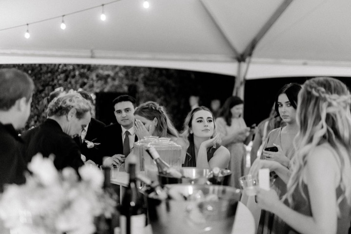 A black-and-white photograph of guests dancing at the reception