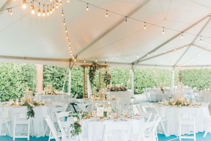 The white reception tent decorated with strings of lights