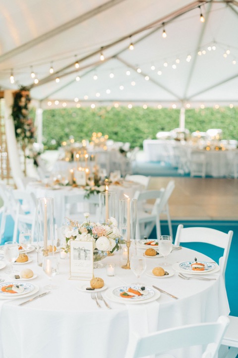 A flower-filled table beneath the reception tent