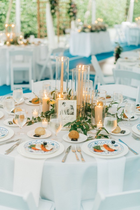 Candleholders, place settings, and blue chairs at the reception