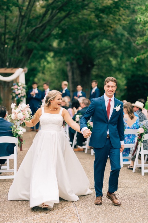 Tyler and Kate smiling as they walk up the aisle