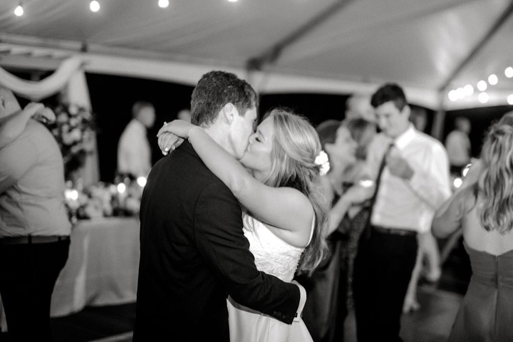 A black-and-white portrait of a couple dancing at the reception