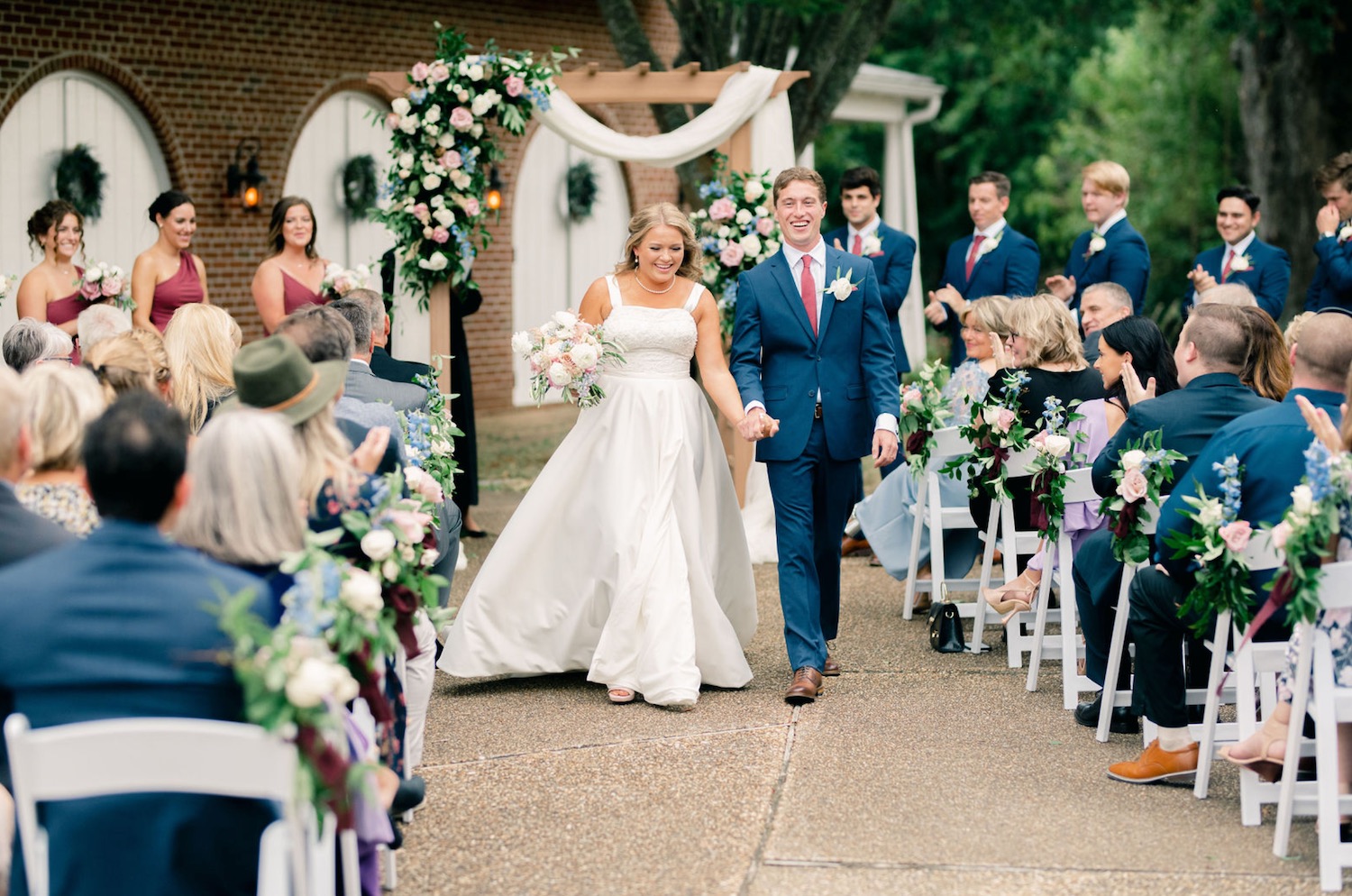 The newlyweds walking past their cheering ceremony guests