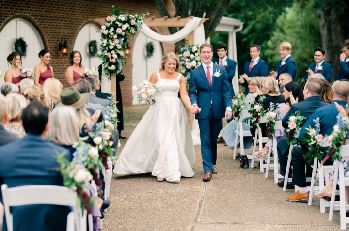 The newlyweds walking past their cheering ceremony guests
