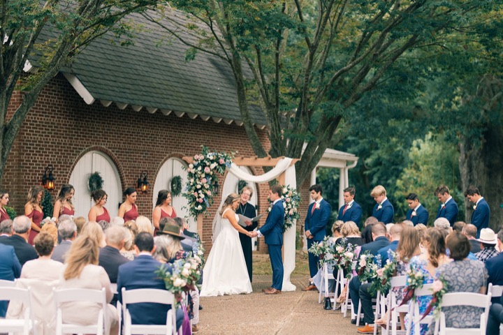 The couple exchanging vows in front of their garden ceremony guests