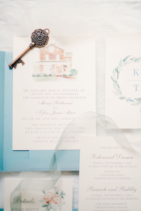 Wedding invitations and stationery arranged with a blue ribbon