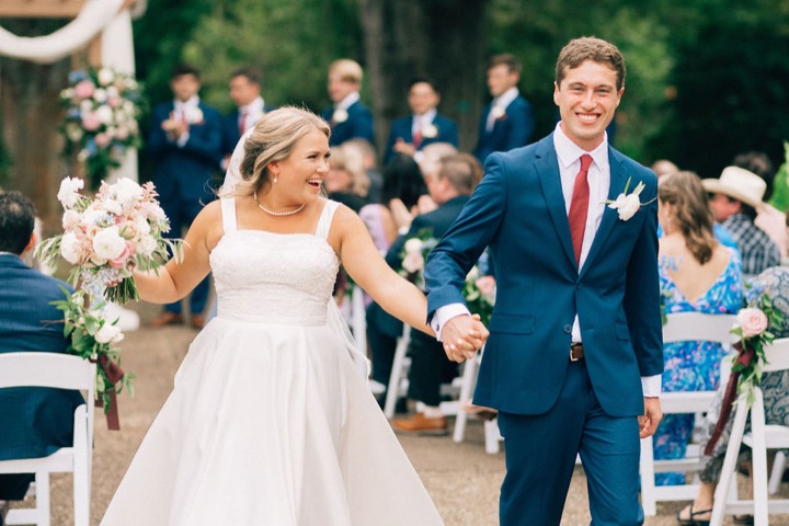 Tyler and Kate walking hand in hand after the ceremony