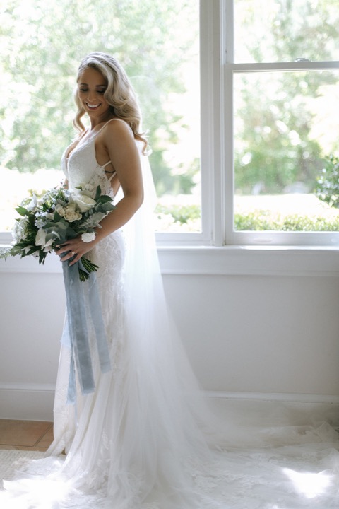 Taylor holding her bouquet beside the cottage window