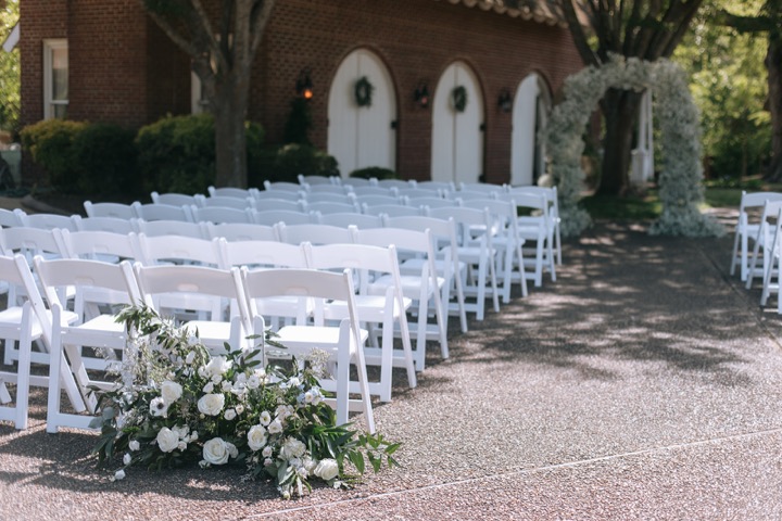 White chairs arranged for the garden ceremony