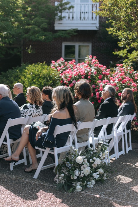 Wedding guests seated among the garden flowers
