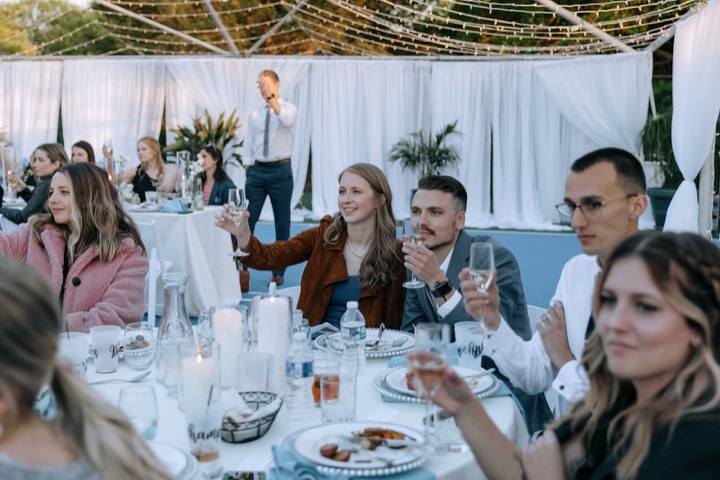 Guests celebrating around the outdoor reception table